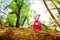 Cute little girl peeping behind fallen tree