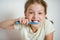 Cute little girl with pigtails diligently brushing his teeth.