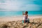 Cute little girl with pilot googles and toy plane travel on summer beach