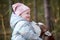 Cute little girl in pink hat and light blue jacket hugs Siberian Husky dog and smiling