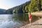 A cute little girl plaing on the bank of a mountain lake on a wa