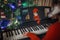 Cute little girl play Christmas melody on piano with support of diy paper santa claus