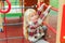 Cute little girl at playground outdoors. Adorable girl with long blonde hair. Happy child climbing on ladder at modern colorful