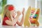 Cute little girl playing with abacus at home. Smart child learning to count.