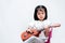 Cute little girl playing brown ukulele in the studio on a white background