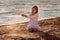 Cute little girl playing with falling sand at the beach