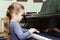 Cute little girl playing grand piano