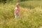 Cute little girl playing in the grass. Outdoors childhood advent