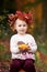 Cute little  girl playing with vegetable marrow in autumn park. Autumn activities for children. Halloween and Thanksgiving time