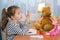 Cute little girl playing with wooden abacus at home. Smart child learning to count. Preschooler having fun with educational toy at