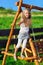 Cute little girl playing on wooden chain swing