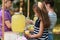 Cute little girl pouring natural lemonade into cup in park