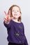 Cute little girl in purple sweat with three years by finger hand