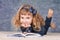 Cute little girl reading book while lying on floor