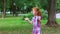 Cute little girl with red hair catches bubbles