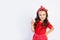 A cute little girl in a red outfit on a white  background shows a thumbs up. Space for text.the concept of the celebration