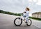 Cute little girl riding fast by bicycle