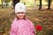 Cute little girl with rose in autmn park