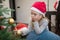 Cute little girl with Santa hat and christmas ball resting on he