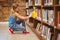 Cute little girl selecting book in library