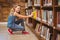 Cute little girl selecting book in library