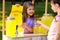 Cute little girl selling natural lemonade to kid. Summer refreshing drink