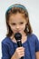 Cute little girl sings a karaoke song with microphone