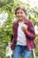 Cute little girl sitting on stepladder at garden and holding fresh apple