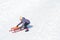 Cute little girl sliding on a sled on snowy hill