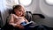 Cute little girl with a smartphone on plane