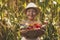 A cute little girl smiles and holds vegetables grown in the garden. Local rural seasonal natural food