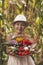 A cute little girl smiles and holds vegetables grown in the garden. Local rural seasonal natural food