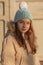 Cute little girl smiles. A teenager in a beige winter jacket looks at the camera. with sunny light