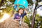 a cute little girl in a straw hat is smiling in a balloon basket.