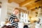 Cute little girl in striped dress sitting on kitchen table.