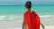 Cute little girl in the superhero costume, dressed in a red cloak and the mask of the hero. Plays on the background sea