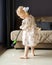 Cute little girl sweeping floor with broom at home