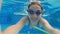 Cute little girl swimming underwater in a pool