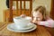 Cute little girl unwilling to eat her soup. Child having a dinner at home