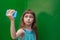 Cute little girl using smartphone on green background.Little girl takes a selfie. generation Z