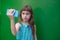 Cute little girl using smartphone on green background.Little girl takes a selfie. generation Z