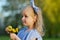 Cute little girl walking in the park with dandelion flowers