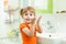 Cute little girl washing hands in bathroom