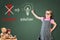 Cute little girl wearing business dress and eliminate problem and find solution on green chalk board.