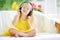 Cute little girl wearing huge wireless headphones. Pretty child listening to the music. Schoolgirl having fun listening to kid`s