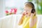 Cute little girl wearing huge wireless headphones. Pretty child listening to the music. Schoolgirl having fun listening to kid`s