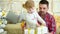 Cute little girl with young father unpack gift boxes near Christmas tree at home