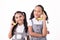 Cute little girls looking at camera pretend conversation on telephone with a banana on isolated white background