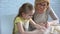 Cute little grandchild studying cook, helping grandmother, homemade patty