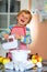 Cute little happy blond preschool kid boy baking apple cake and muffins in domestic kitchen. Funny lovely healthy child